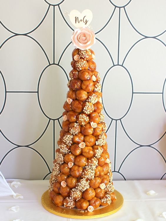 a beautiful croquembouche wedding cake with caramel and sugar detailing, sugar blooms and a sugar rose on top