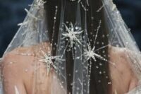 a beautiful heavily embellished silver star veil paired with a matching wedding dress are a gorgeous combo for a celestial bride