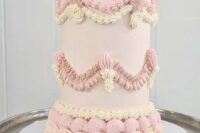 a blush and pale pink plus ivory tall lambeth wedding cake topped with cherries is a cool and tender piece for a wedidng