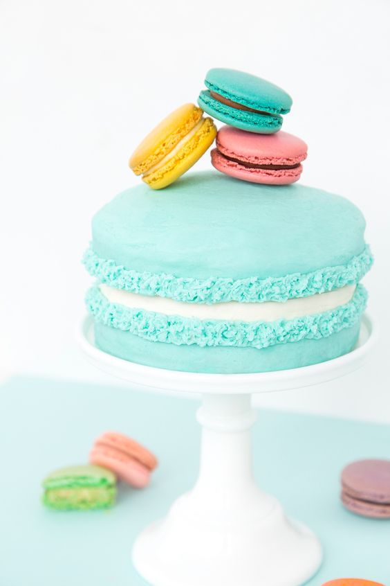 a bold turquoise macaron cake topped with colorful macarons is a lovely and bold idea for a spring or summer wedding