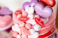 a bright macaron wedding cake in pink, red and purple, with meringues, heart-shaped macarons and lip candies