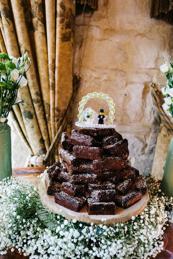 a brownie stack topped with a fun Lego topper surrounded with white baby's breath is a cool solution for a casual wedding