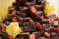 a brownie stack with fresh blooms and strawberries is a lovely idea for a wedding, it will please a whole crowd