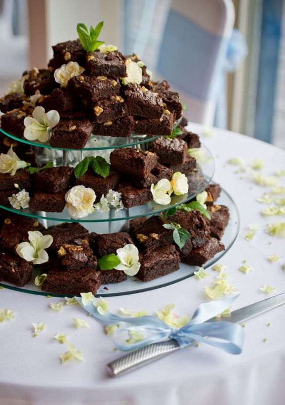 a brownie wedding cake decorated with greeneyr and neutral blooms will be an elegant and delicious wedding cake alternative
