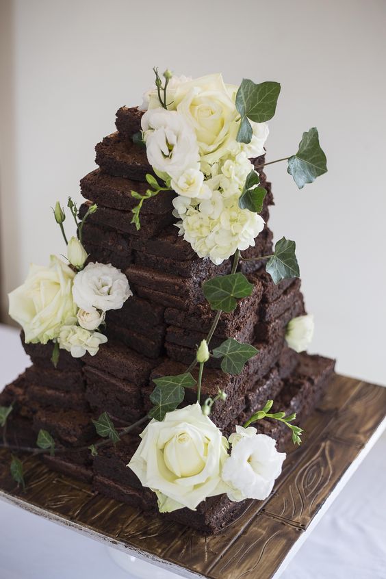a brownie wedding cake topped with fresh white blooms and elaves is a dreamy and catchy alternative to a usual wedding cake