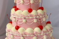 a catchy pink wedding cake with neutral sugar detailing and bold red cherries all over the cake is a trendy idea for a wedding