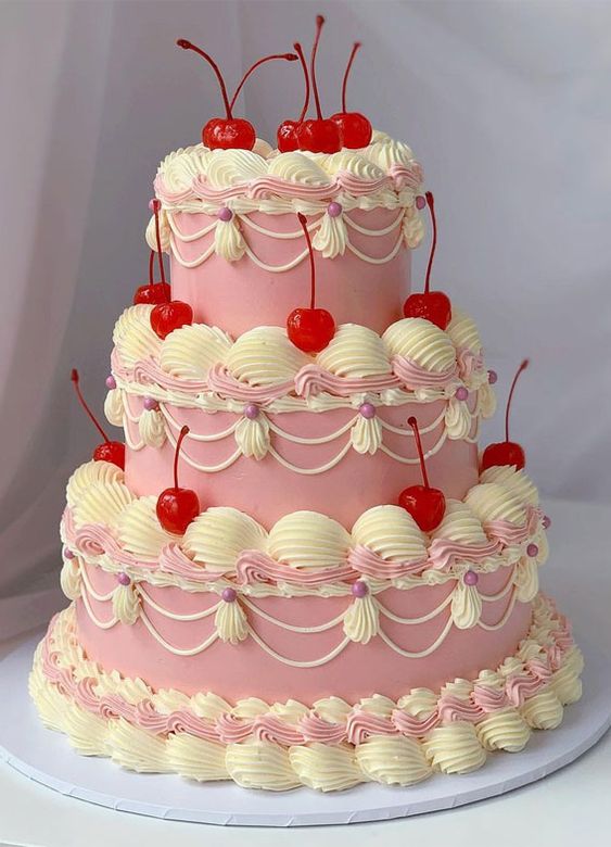 a catchy pink wedding cake with neutral sugar detailing and bold red cherries all over the cake is a trendy idea for a wedding