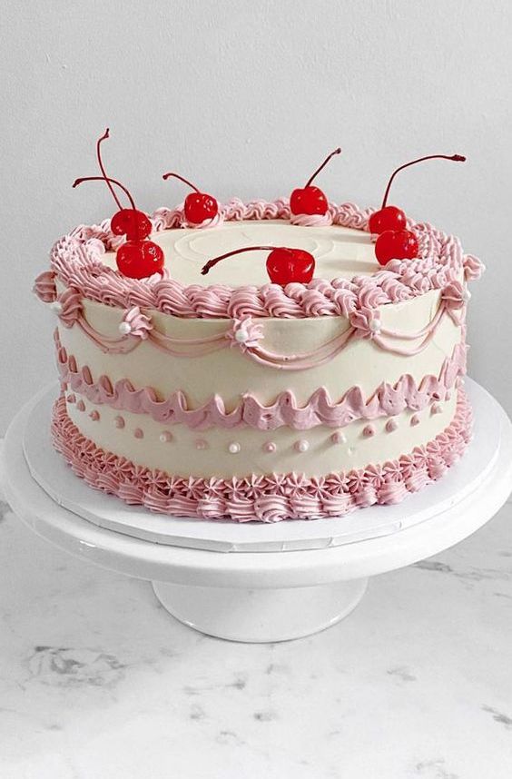 a classic lambeth wedding cake with pink sugar patterns and cherries on top is a stylish idea for a spring or summer wedding