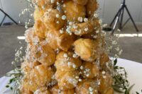 a classy croquembouche wedding cake with sugar icing, baby’s breath and monograms on top is a great and chic idea