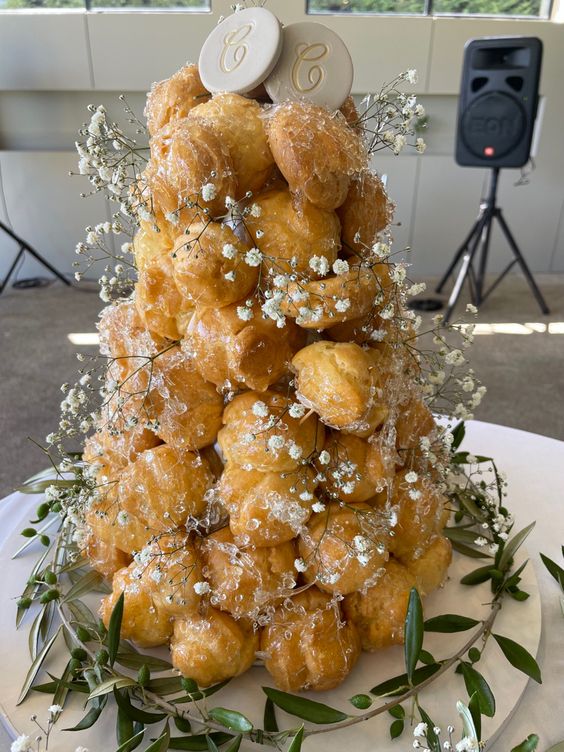 a classy croquembouche wedding cake with sugar icing, baby's breath and monograms on top is a great and chic idea