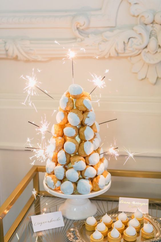 a classy small croquembouche decorated with icing and sparklers will be a nice idea for a NYE wedding