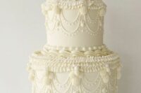 a classy white lambeth wedding cake with sugar detailing and a traditional cake topper is an elegant idea for a wedding