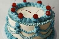 a cool blue and ivory lambeth wedding cake with sugar detailing and red cherries on top is amazing for a summer wedding