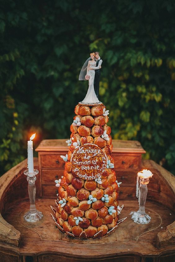 a cool croquembouche wedding cake with candies, a traditional cake topper and a cookie wedding date