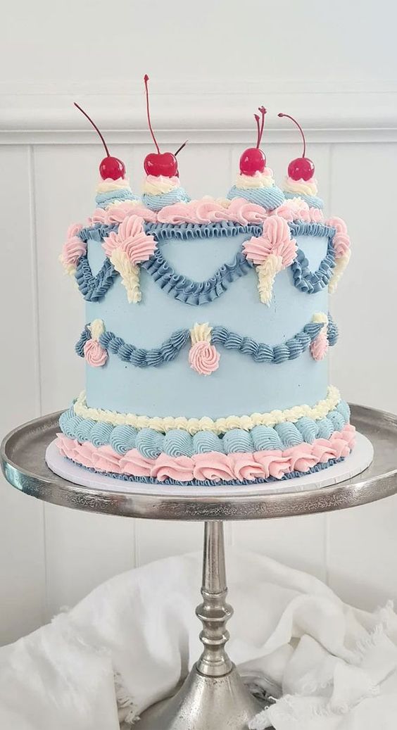 a cool pastel wedding cake in blue, pink and ivory, with much sugar detailing and cherries on top is amazing for spring or summer