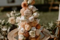 a creative tiny croquembouche that consists of puff pastry and meringues and macarons plus white blooms