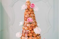 a croquembocuhe with caramel touches, pink and blush blooms is a sophisticated and cool idea for a wedding