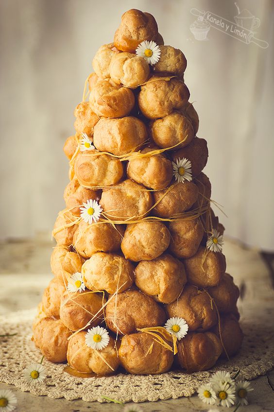 a croquembouche decorated with sugar swirls and little chamomiles is a nice idea for a summer boho wedding