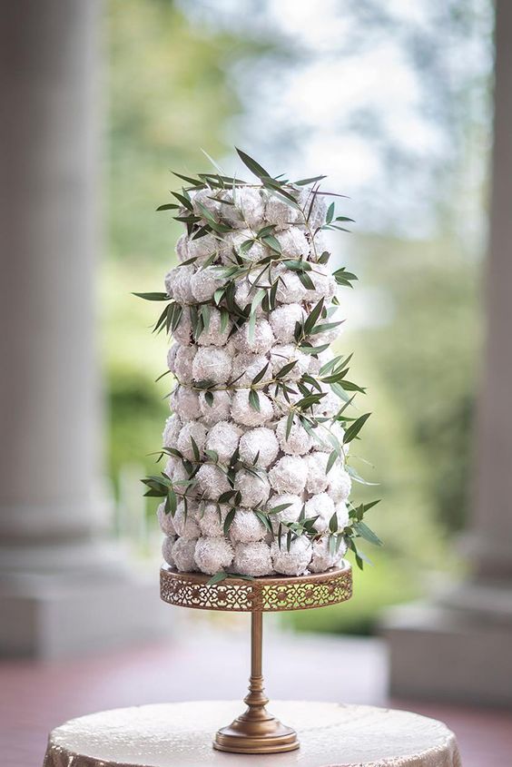 a croquembouche with icing and greenery is a stylish and refined wedding dessert idea for your celebration