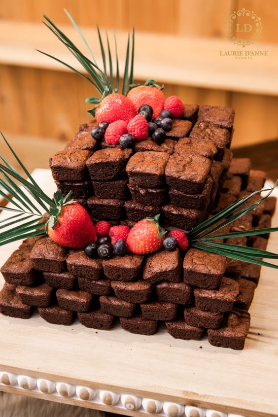 a delicious brownie wedding cake topped with fresh berries and some fronds is a great idea for a relaxed and fun wedding