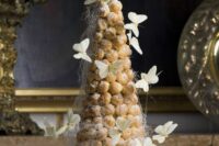 a dreamy croquembouche decorated with icing and white butterflies is amazing for a summer or garden wedding