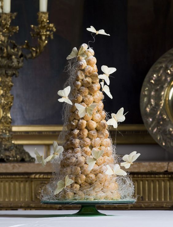 a dreamy croquembouche decorated with icing and white butterflies is amazing for a summer or garden wedding