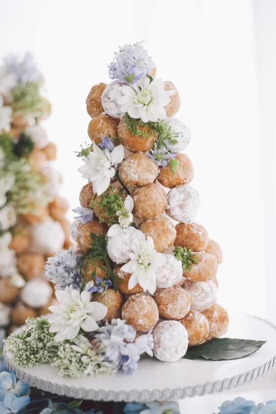 a dreamy croquembouche decorated with lilac and white blooms and a bit of sugar icing is a lovely idea for a spring or summer wedding