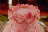 a fantastic pink lambeth wedding cake with sugar patterns, stars and pearls, hearts and cherries on top is amazing