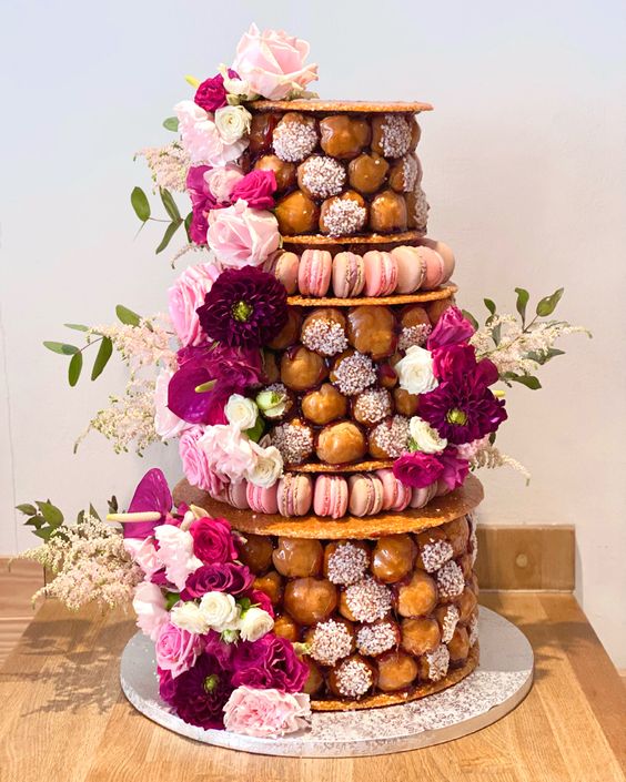 a gorgeous croquembouche with waffle tiers as stands, with pink, white and fuchsia blooms and greenery is amazing