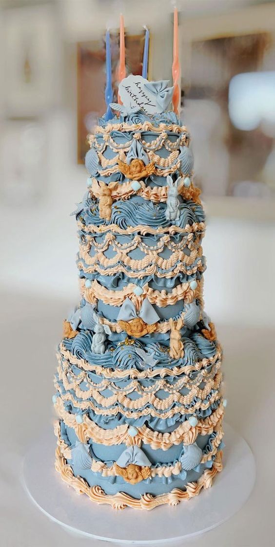 a jaw-dropping blue and beige tall lambeth wedding cake with lots of sugar decor and tall candles on top is a chic idea