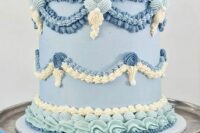 a lambeth wedding cake done in various shades of blue and ivory, with sugar patterns and sugar decor on top is amazing