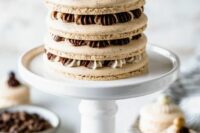 a large coffee macaron wedding cake topped with chocolate and cream is an amazing idea for a wedding