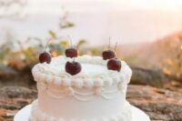 a lovely and cool white lambeth wedding cake with sugar detailing and cherries on top is amazing for a trendy wedding