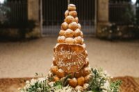 a lovely croquembouche topped with sugar powder and with the names of the couple is a cool idea for a boho wedding