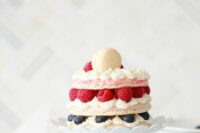 a macaron cake with vanilla cream, fresh berries and a mini macaron on top is a gorgeous idea to rock