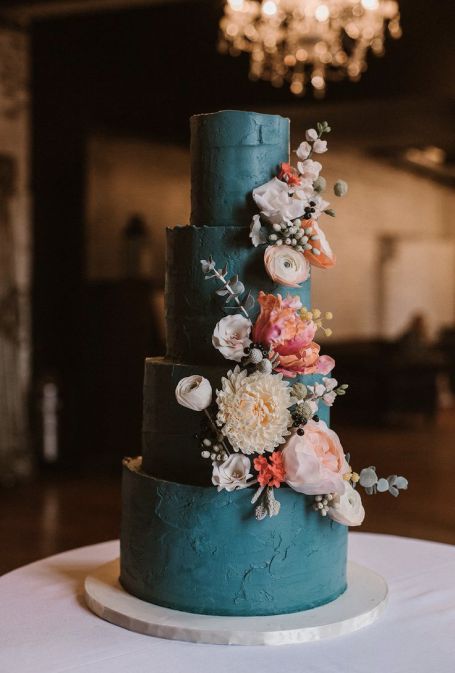 a matte teal wedding cake with a texture, neutral and pink blooms and greenery, some berries is a stylish idea for a fall wedding