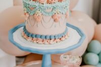 a pretty bright lambeth wedding cake done in pink, turquoise, blue, various sugar patterns and cherries placed on top