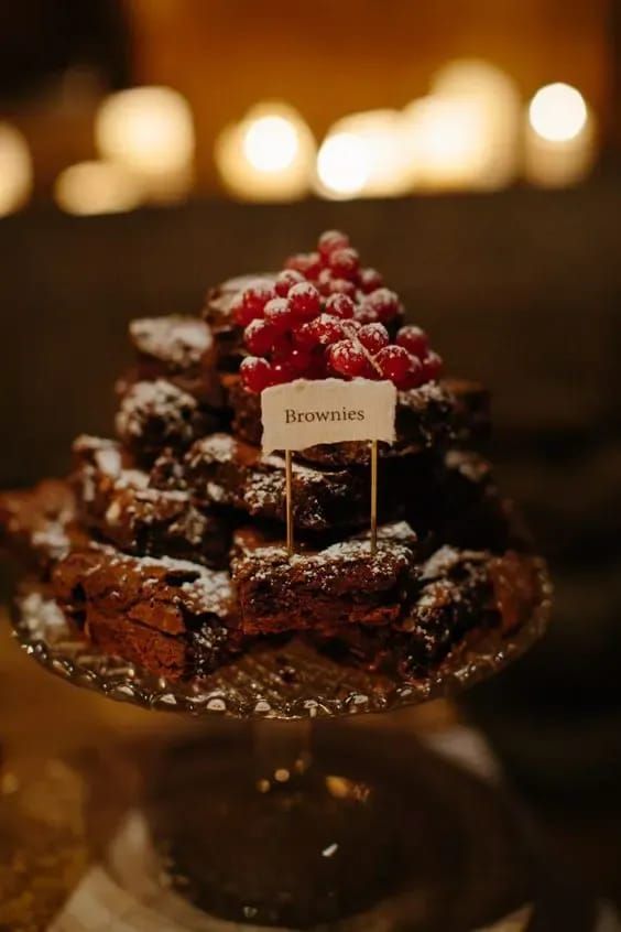 a pretty brownie stack topped with fresh berries and with a little sign is a cool idea for a casual wedding
