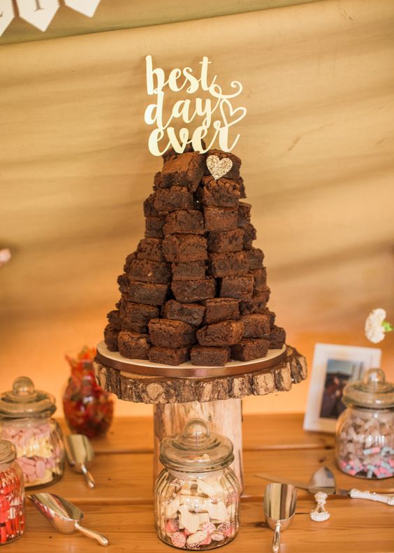 a rustic stand with a brownie stack and a gold calligraphy cake topper plus a glitter heart is amazing for a rustic wedding