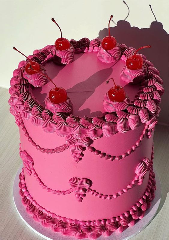 a saturated pink lambeth wedding cake with cherries on top is an amazing and super bold idea for a fall wedding