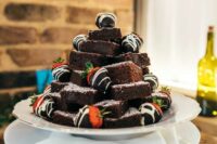 a small and cool brownie stack topped with chocolate strawberries is a cool solution for a rustic or casual wedding