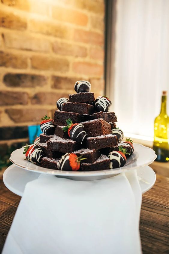 a small and cool brownie stack topped with chocolate strawberries is a cool solution for a rustic or casual wedding