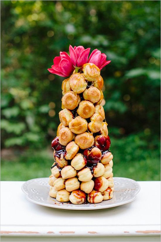 a small and delicious croquembouche topped with fresh berry jam and pink blooms is a great idea for a summer wedding