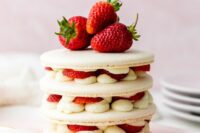a strawberry shortcake macaron cake with vanilla cream, fresh berries inside and on top is a refined wedding dessert idea