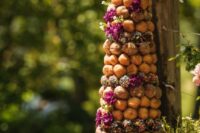 a tall croquembouche with funfetti and bold fuchsia blooms plus donuts are great for a summer wedding