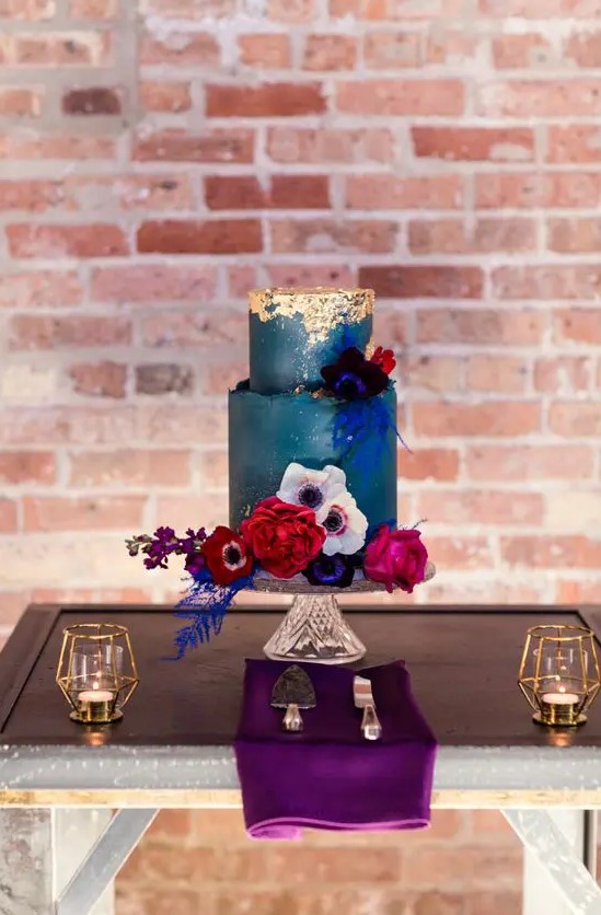 a teal wedding cake with a textural edge and gold leaf on top, with bold blooms and foliage is a lovely idea for a fall wedding