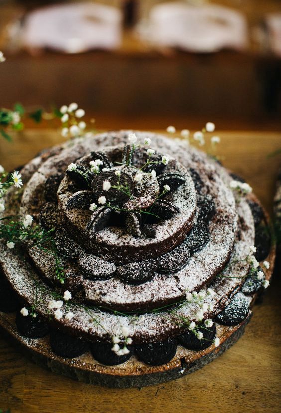 a tiered brownie wedding cake topped with baby's breath and some greenery is a cool idea for a boho wedding