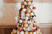 a wedding croquembouche with fresh blackberries and strawberries, some sugar styling and doilies looks unusual and refined