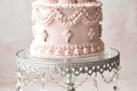 an elegant blush lambeth wedding cake with sugar patterns, gold beads and dark gilded cherries on top for a chic wedding