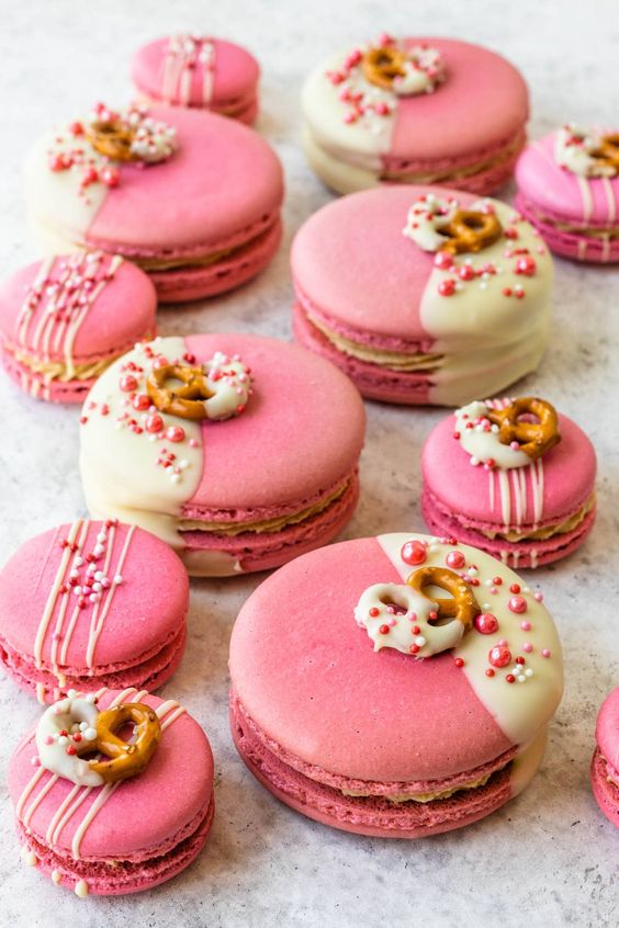 large and small pink and white macarons topped with edible beads and pretzels are adorable as an alternative to a wedding cake